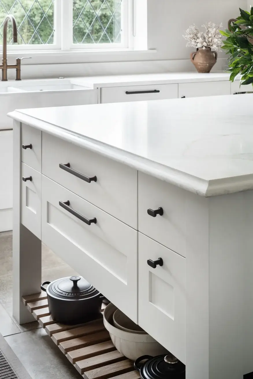 bespoke kitchen island in white with a wooden shelf below drawers and white worktop