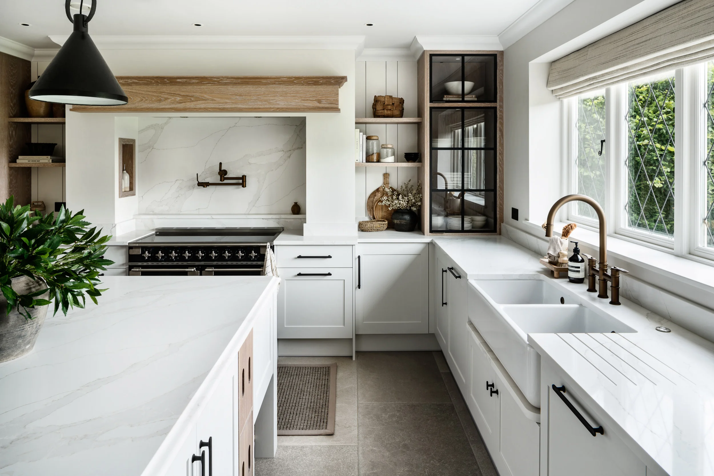 Bespoke Kitchen with white bespoke cabinetry and farmhouse sink with plants on the worktop