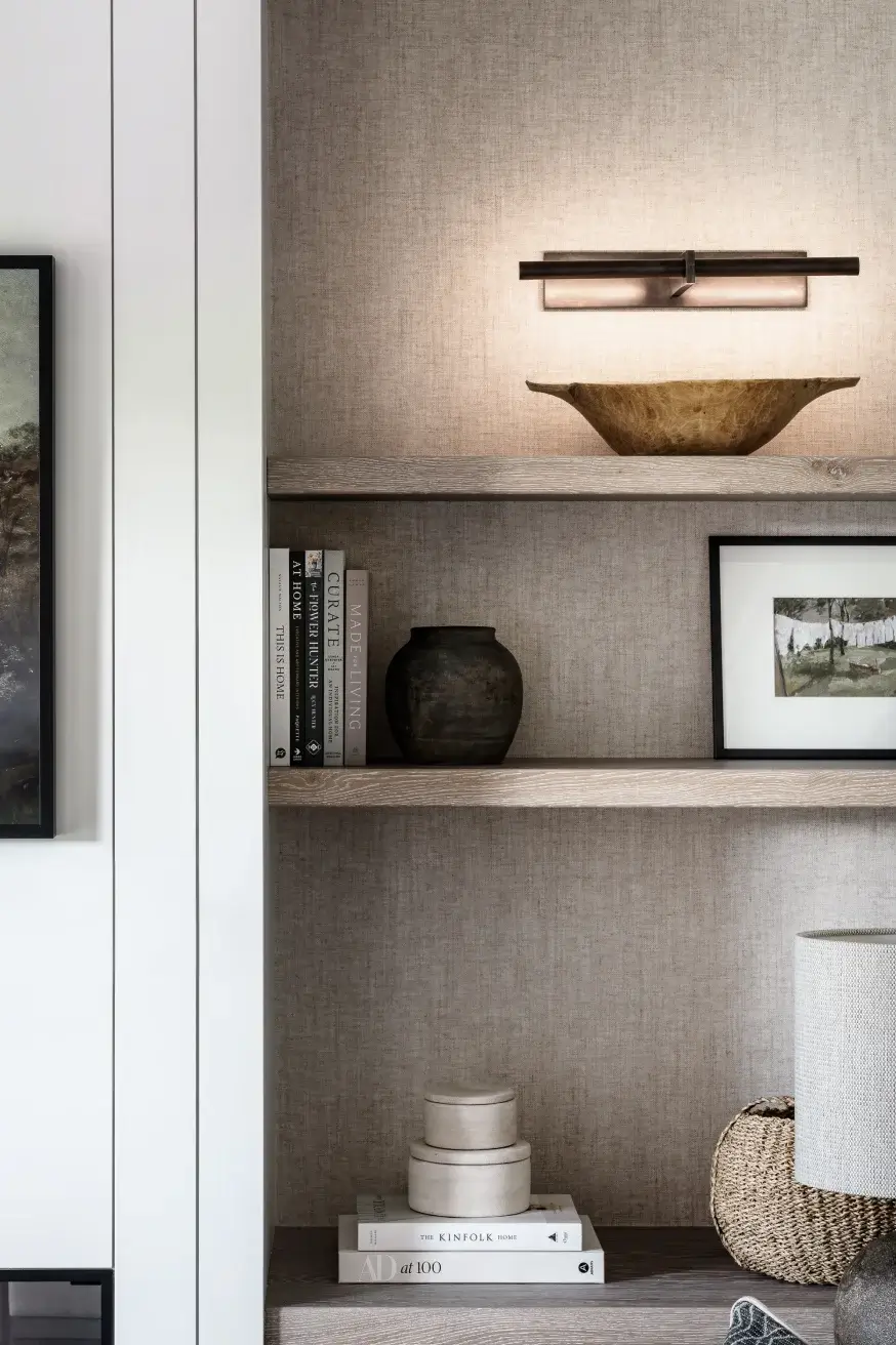 Fitted furniture bookcase with white cladding on the wall and accessories on the shelves