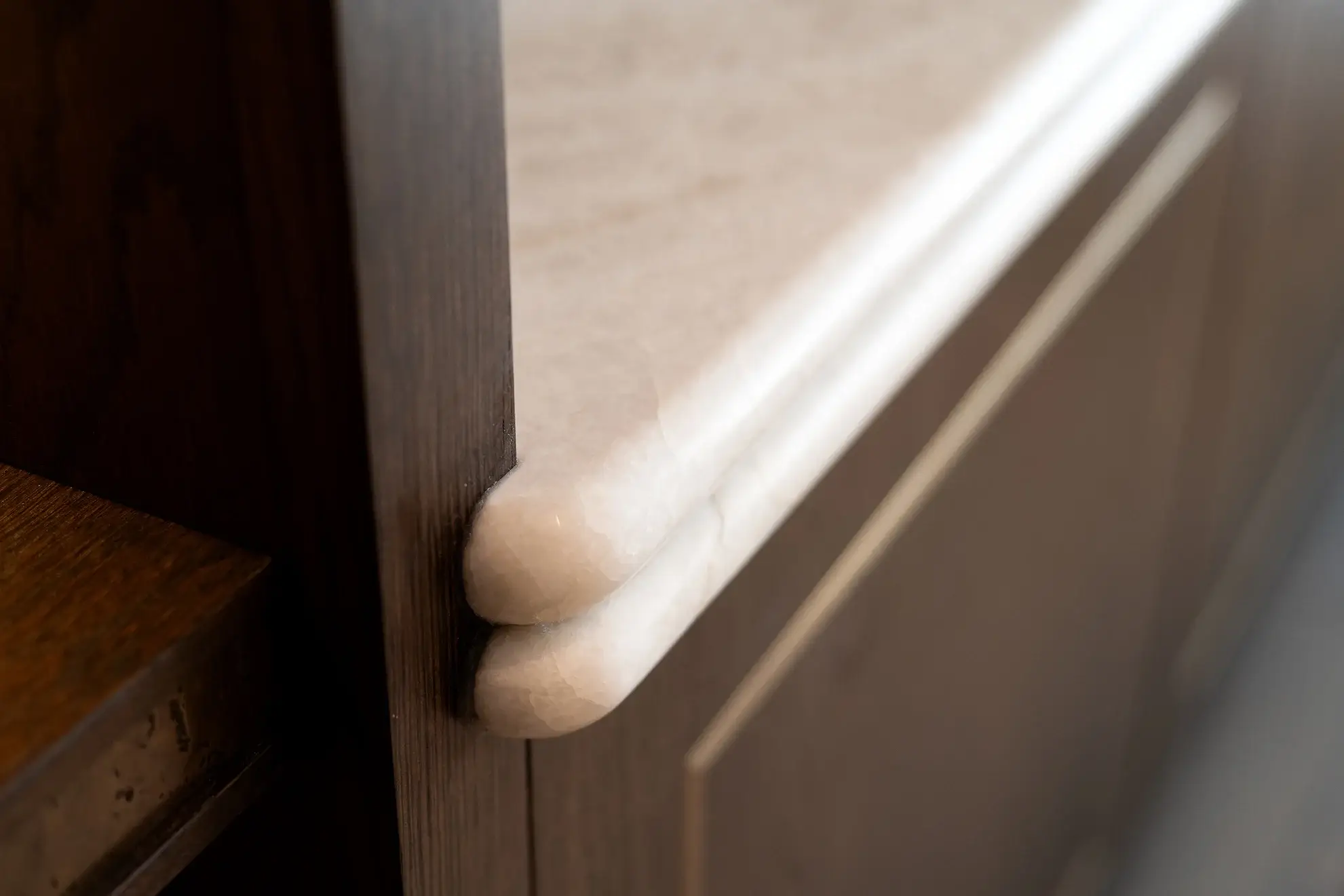 Close-up of bullnose marble edge detail on custom media wall cabinetry